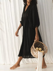 Black tie-neck midi dress with puff sleeves and lace detail.