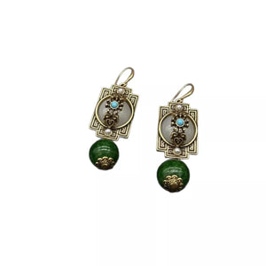 Vintage gold-plated dangle earrings with dark green beads and white accents.
