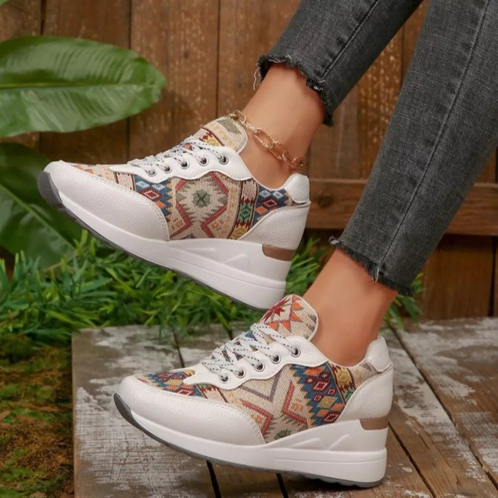 White wedge sneakers with geometric pattern and lace-up closure.