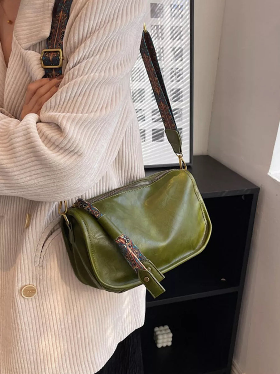 Green textured strap mini crossbody bag with adjustable strap and zip closure.