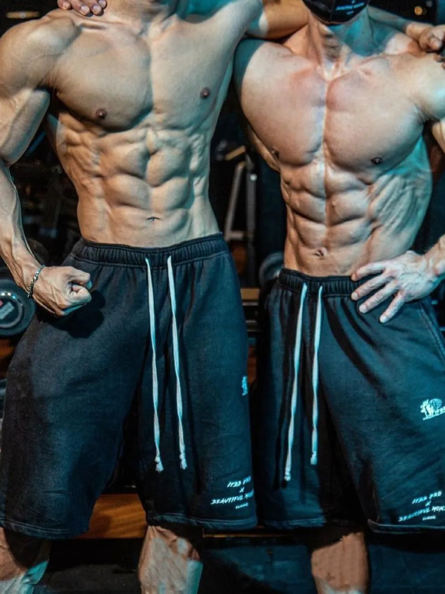Black performance fleece jogger shorts with white drawstrings and subtle graphic details.
