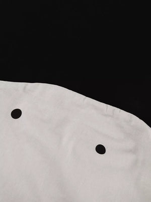 White dress with black polka dots and a round neckline.