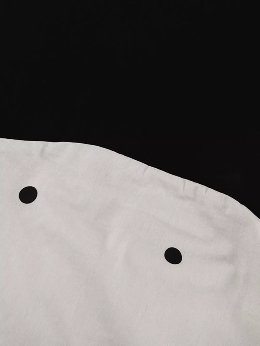 White dress with black polka dots and a round neckline.