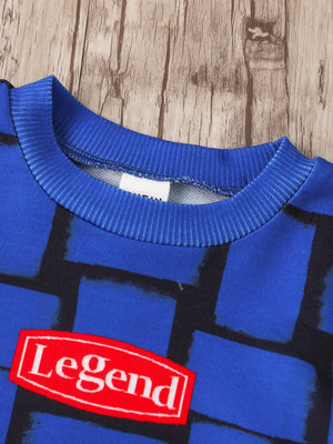 Children's blue graphic tee with abstract block pattern and red "Legend" patch detail.
