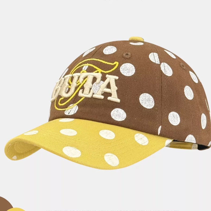 Brown polka dot baseball cap with yellow brim and embroidered text.