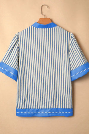 Blue and white striped shirt with decorative stitching and color block accents.