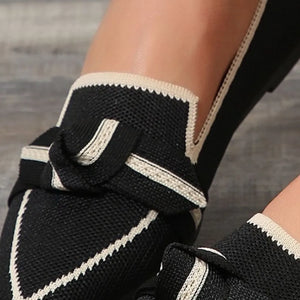 Black knit bow loafers with contrast trim and scalloped edge detail.