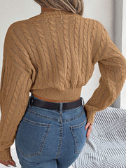 Camel cable knit cropped sweater with twist front detail and balloon sleeves.