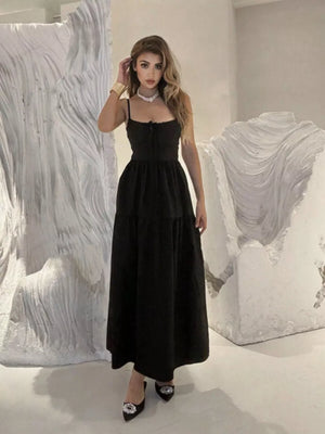Black backless maxi dress with spaghetti straps and crisscross detail, tiered skirt.