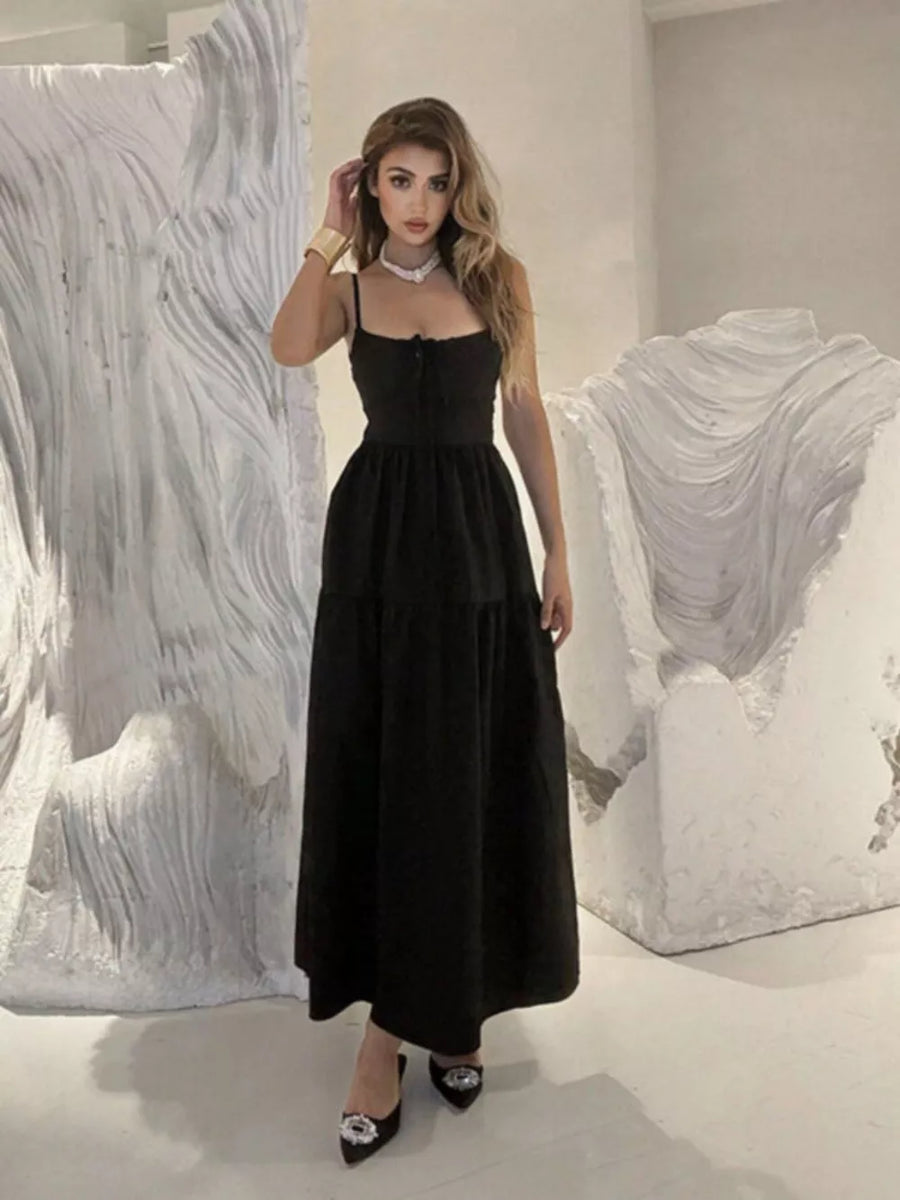 Black backless maxi dress with spaghetti straps and crisscross detail, tiered skirt.