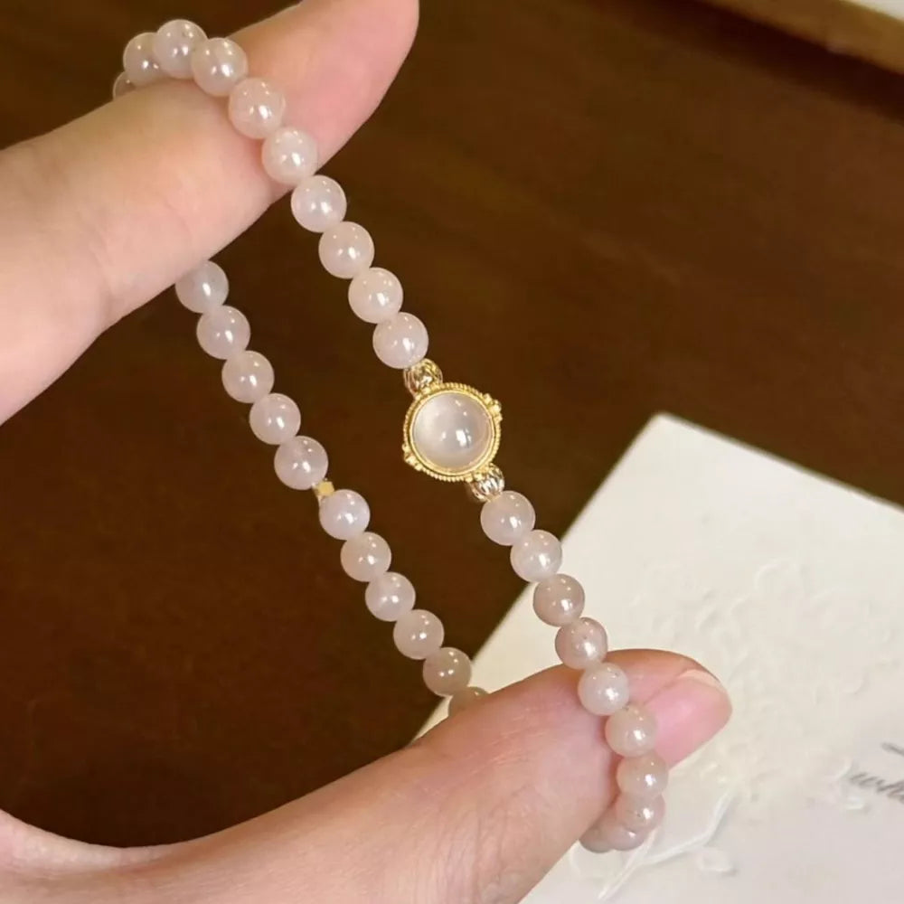 Gold-plated bracelet with blush pink moonstone beads and a central cabochon.
