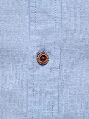 Light blue linen shirt with embroidered button detail.