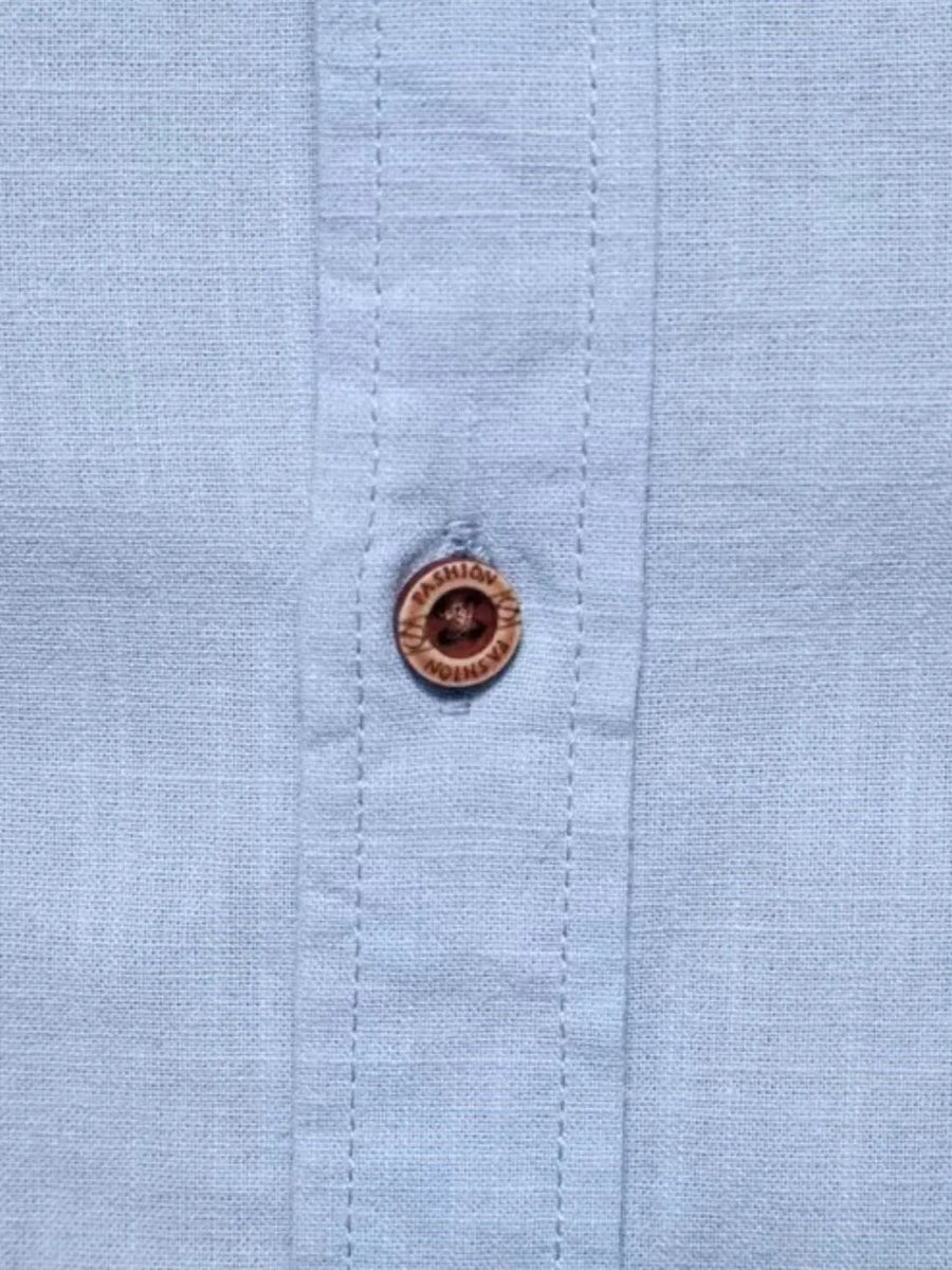 Light blue linen shirt with embroidered button detail.