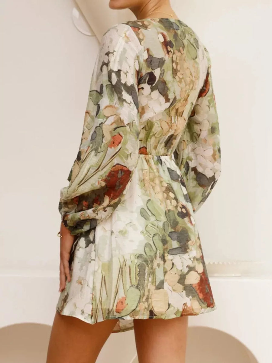 V-neck tie waist dress with abstract floral print, balloon sleeves, and a mini hem.
