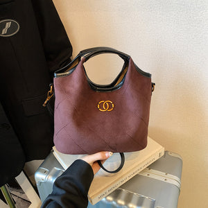 Deep purple quilted suede tote bag with diamond pattern and gold logo detail