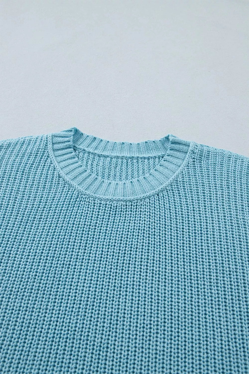 Relaxed ribbed knit sweater top in light blue with crew neck and textured cotton fabric.