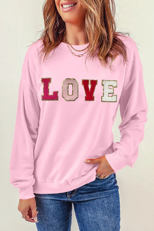 Blush pink sweatshirt with embellished LOVE lettering and gold trim.