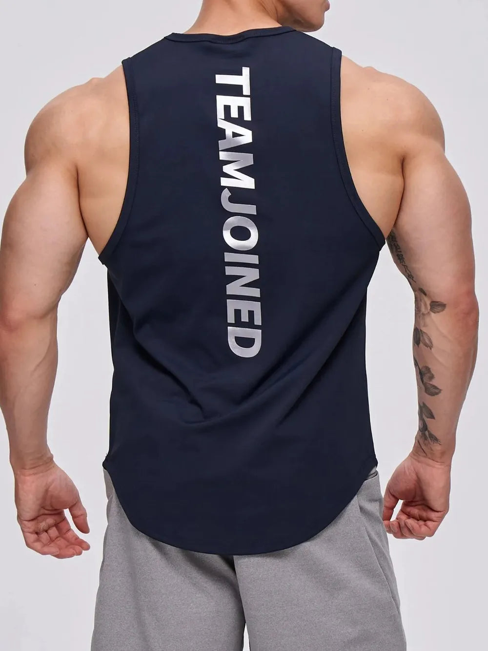 Navy performance tank top with vertical white TEAM.JOINED graphic on back