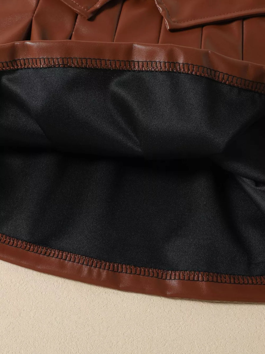 Brown faux leather pleated skirt with black lining and contrast stitching detail.