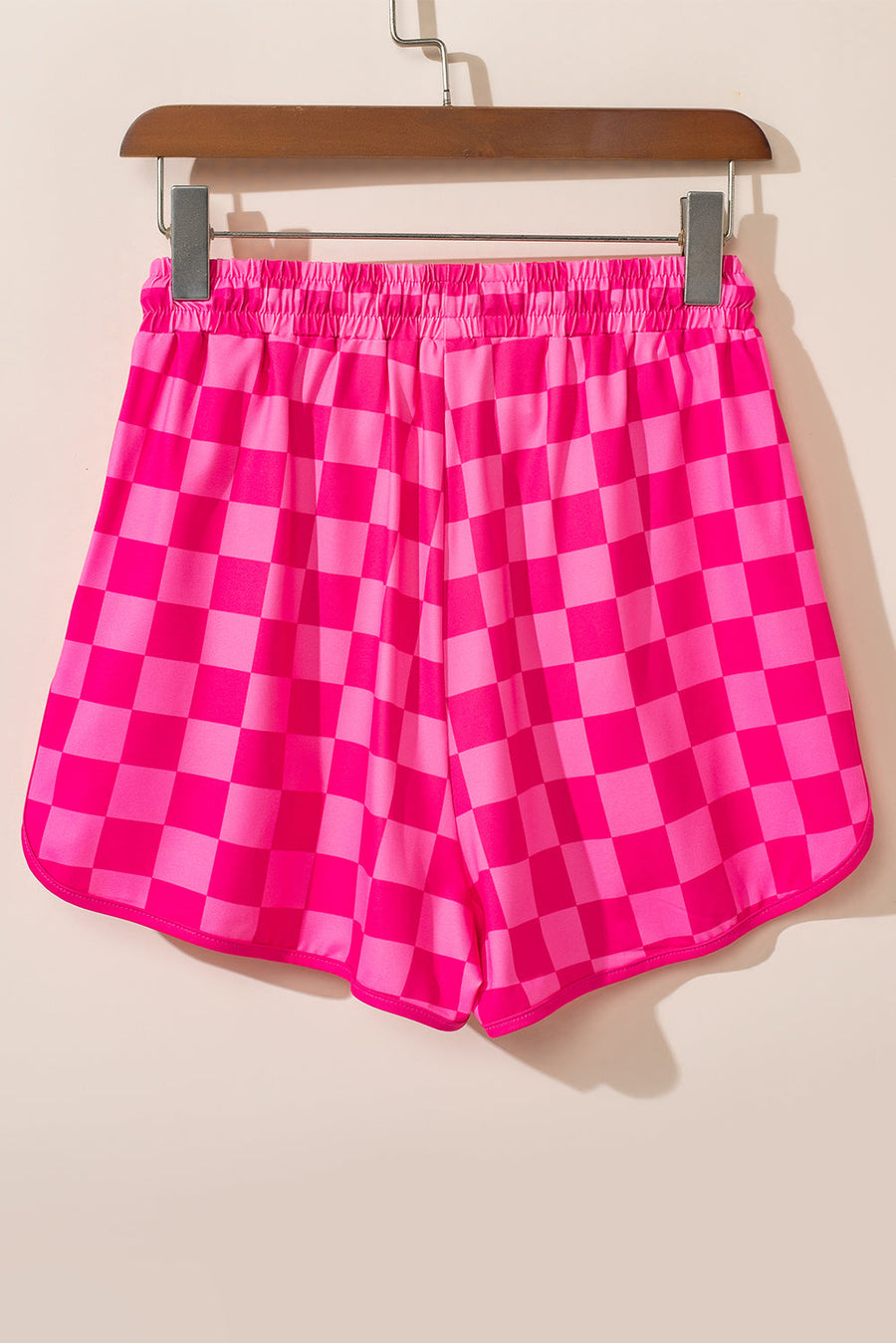 Hot pink checkerboard lounge shorts with elastic waistband and curved hem.