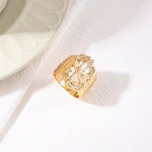 ring in Gold with graphic and dollar sign motif