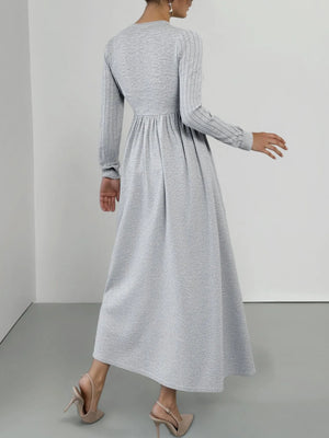 Light gray long sleeve V-neck maxi dress with ribbed sleeves and a flowing skirt.