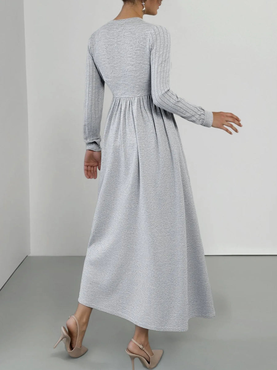 Light gray long sleeve V-neck maxi dress with ribbed sleeves and a flowing skirt.