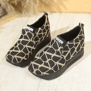 Black and beige geometric patterned slip-on sneakers with platform soles.
