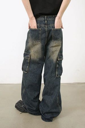 Distressed dark wash denim wide-leg cargo pants with zip pockets and a relaxed fit.