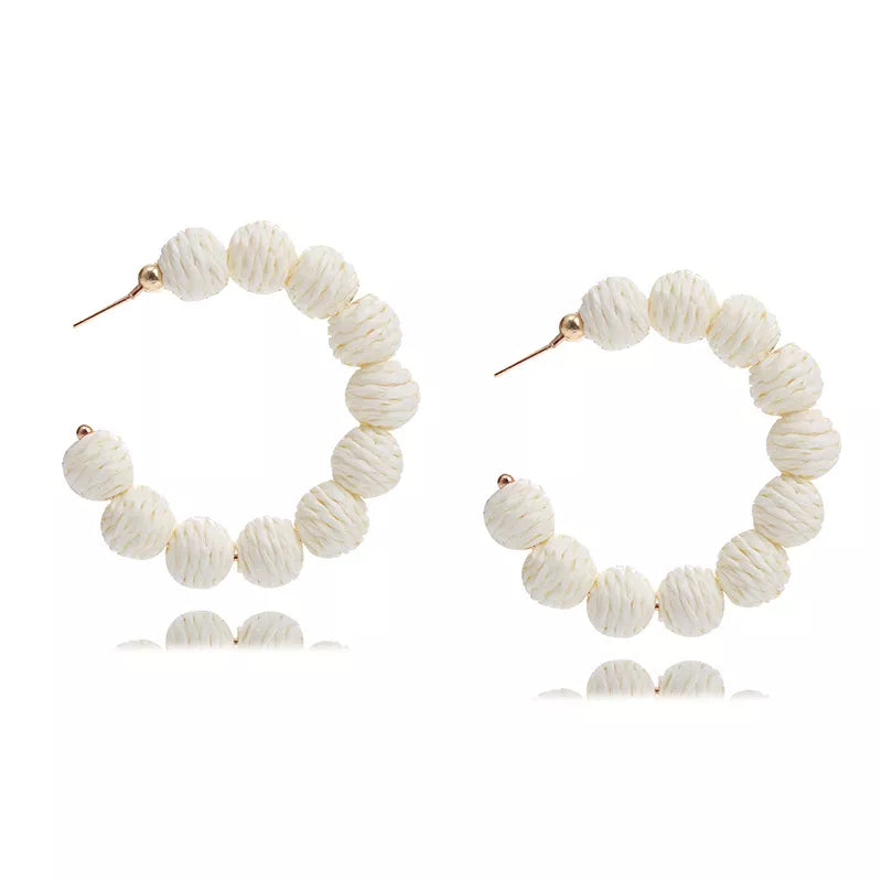 Raffia grass C-hoop earrings in beige with textured spherical beads and gold posts.