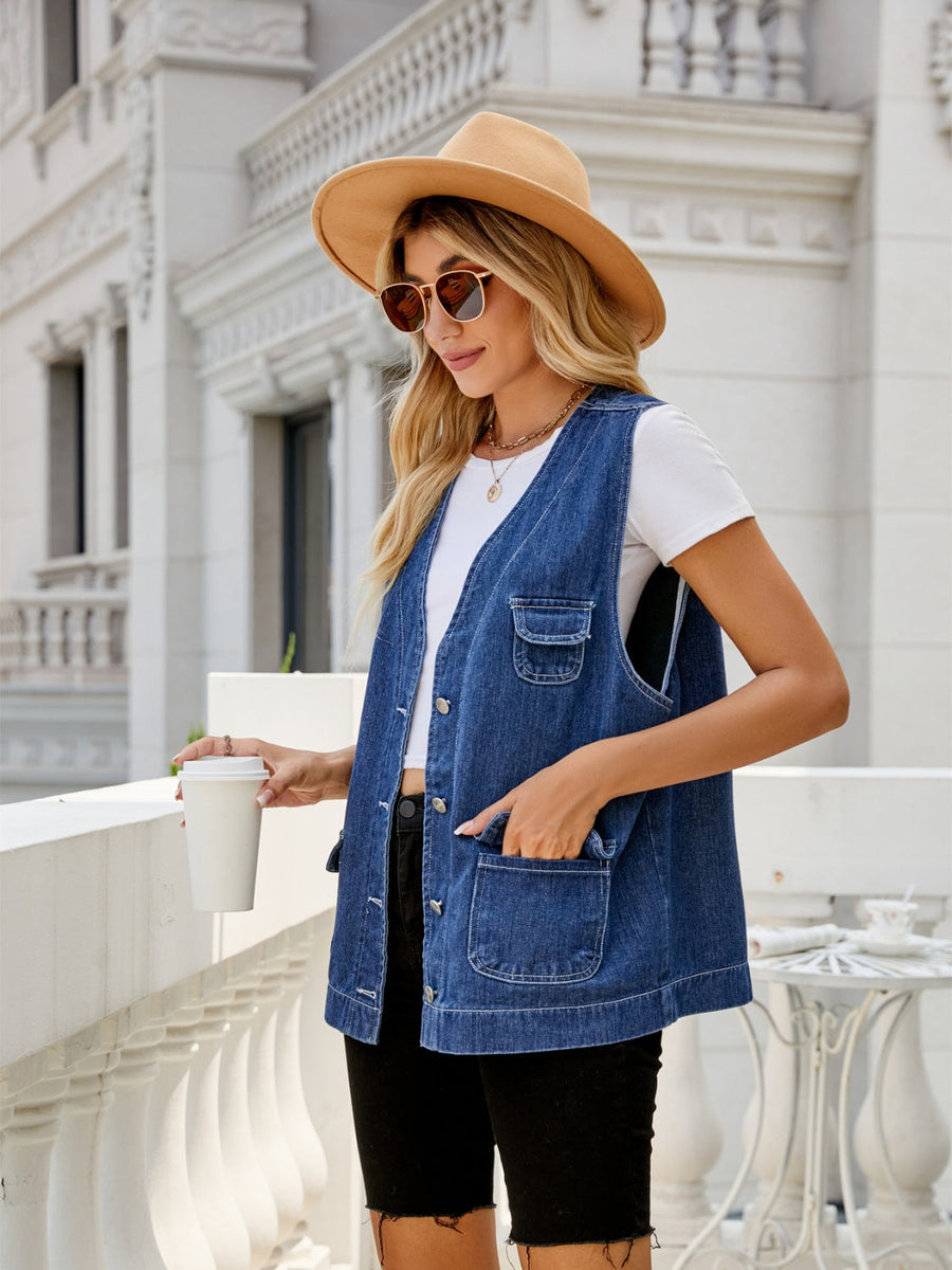 Utility denim vest in medium dark wash with button front and chest pockets.