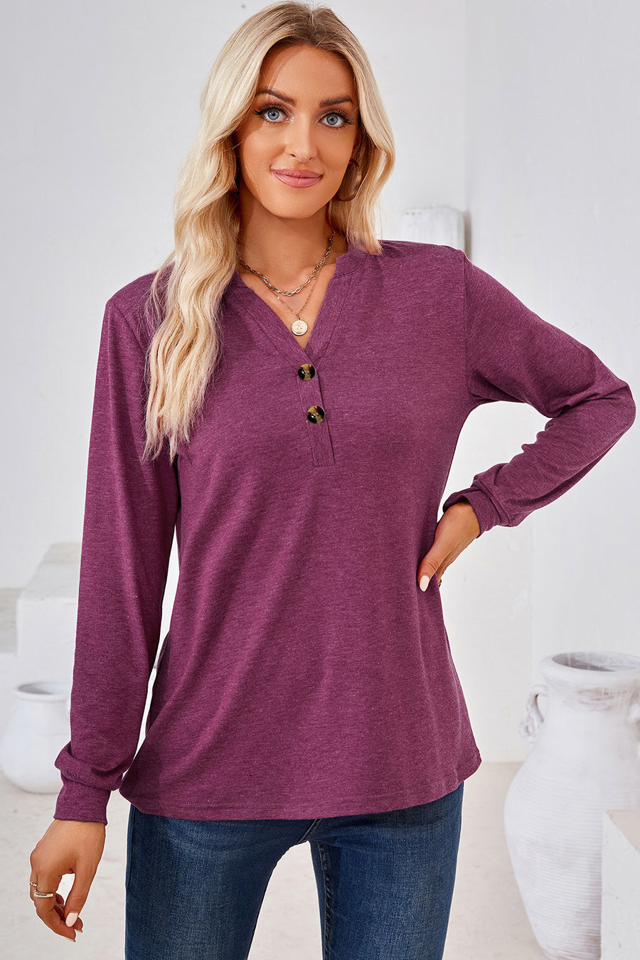 Henley button-down knit top in a deep plum color with a V-neck and two dark buttons.