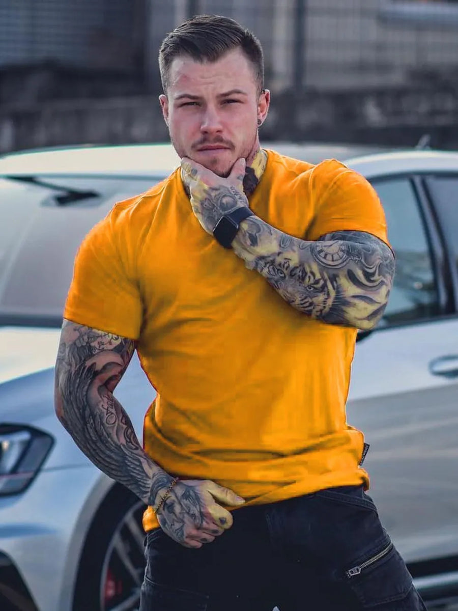 Gold muscle fit crew neck tee with short sleeves on a man with tattoos.