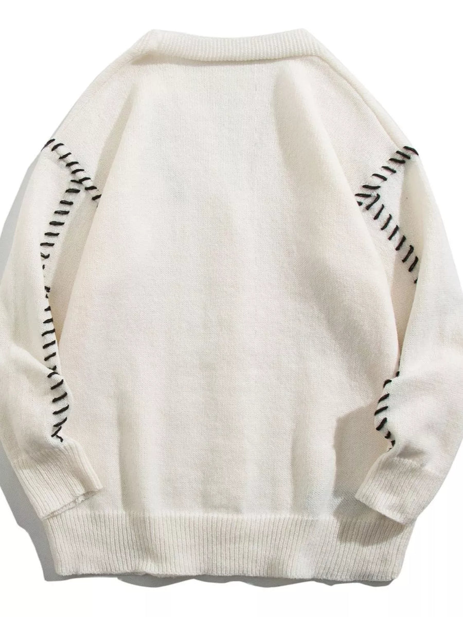 White ribbed V-neck cardigan with black contrast stitching detail on sleeves and shoulders.