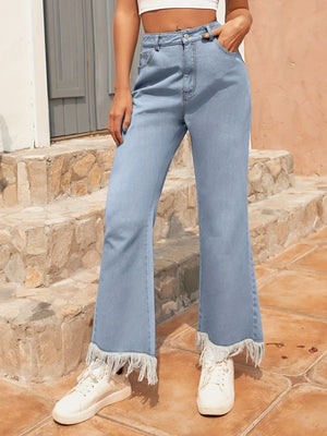 Light wash denim flare jeans with a fringed hem detail.