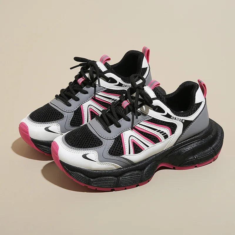Chunky mesh runner sneakers with black, white, gray, and hot pink accents and a thick black sole.