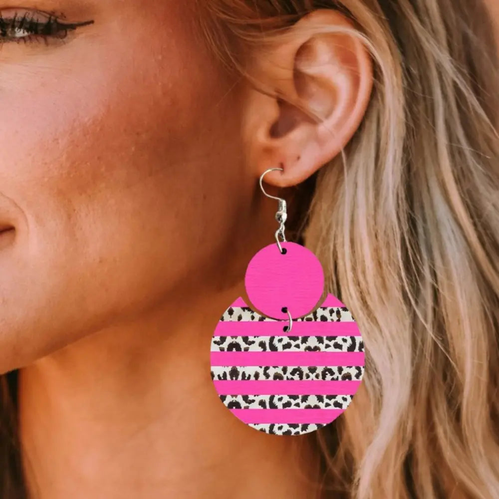 Hot pink statement earrings with leopard print and stripes.