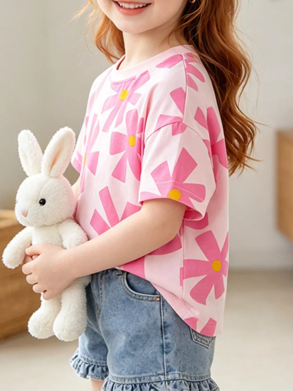 Pink cotton t-shirt for kids with a bold pink floral print and yellow centers, crew neck, short sleeves.