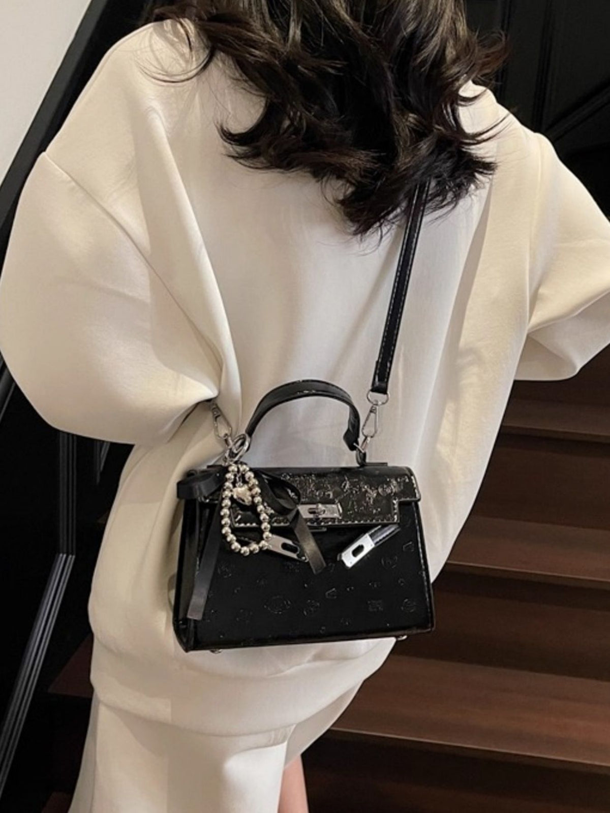 Black embossed mini pu leather crossbody bag with silver hardware and charm