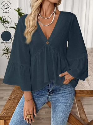 Navy blue cotton V-neck blouse with bell sleeves and a button detail.