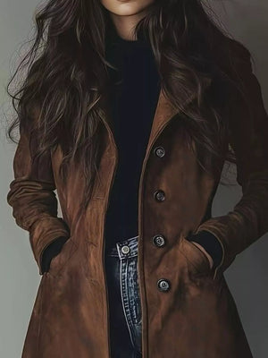 Brown long-sleeve trench coat with buttoned front and pockets, styled with a black turtleneck and jeans.