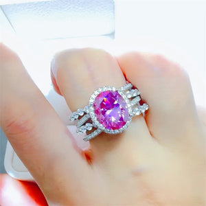 Radiant Halo & Stacked Gem Ring in silver with a large oval pink center stone and clear accent stones.