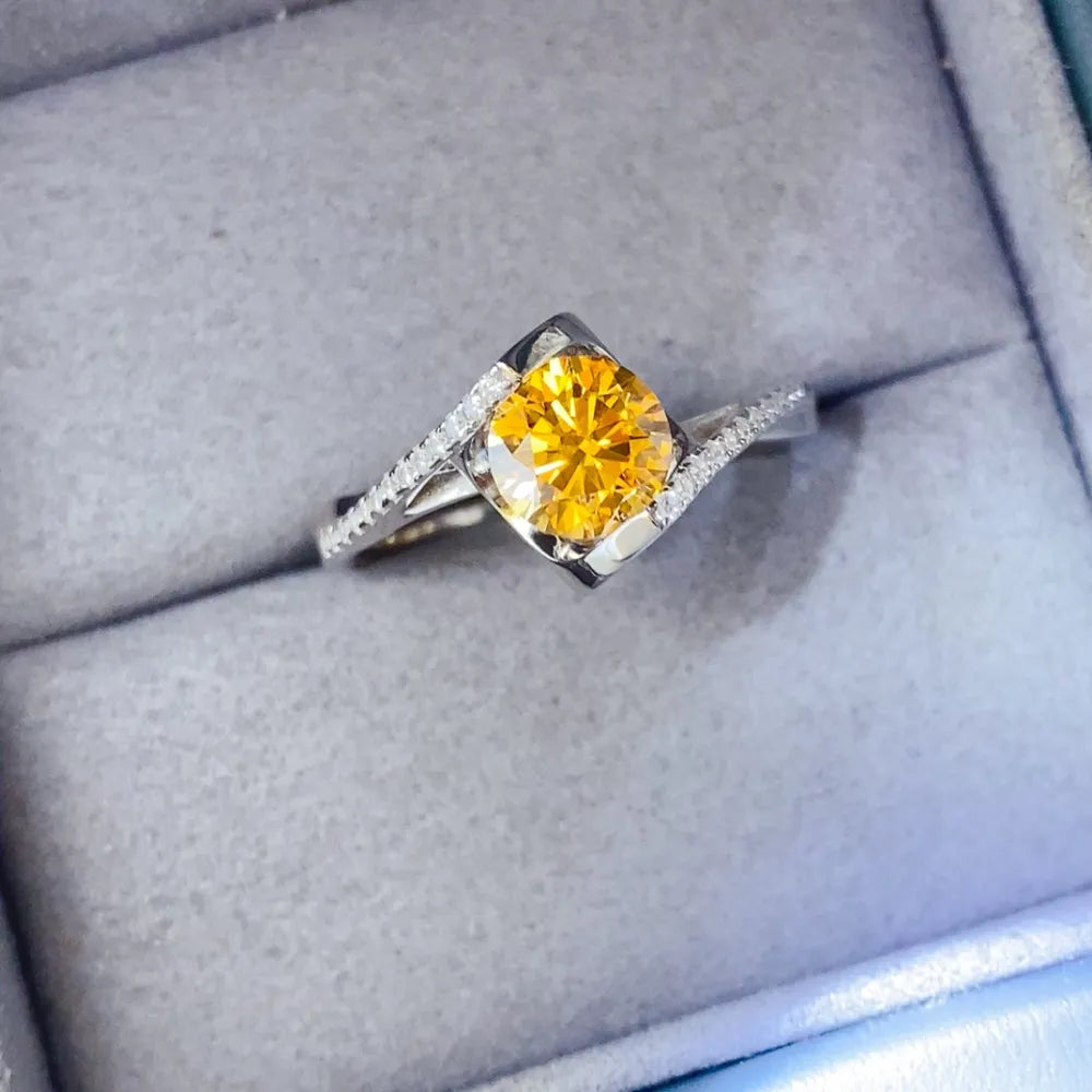 Silver twist ring with a bright yellow moissanite and diamond accents.