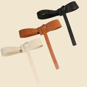 Tied waistband belt with elongated tail in ivory, caramel, and black.