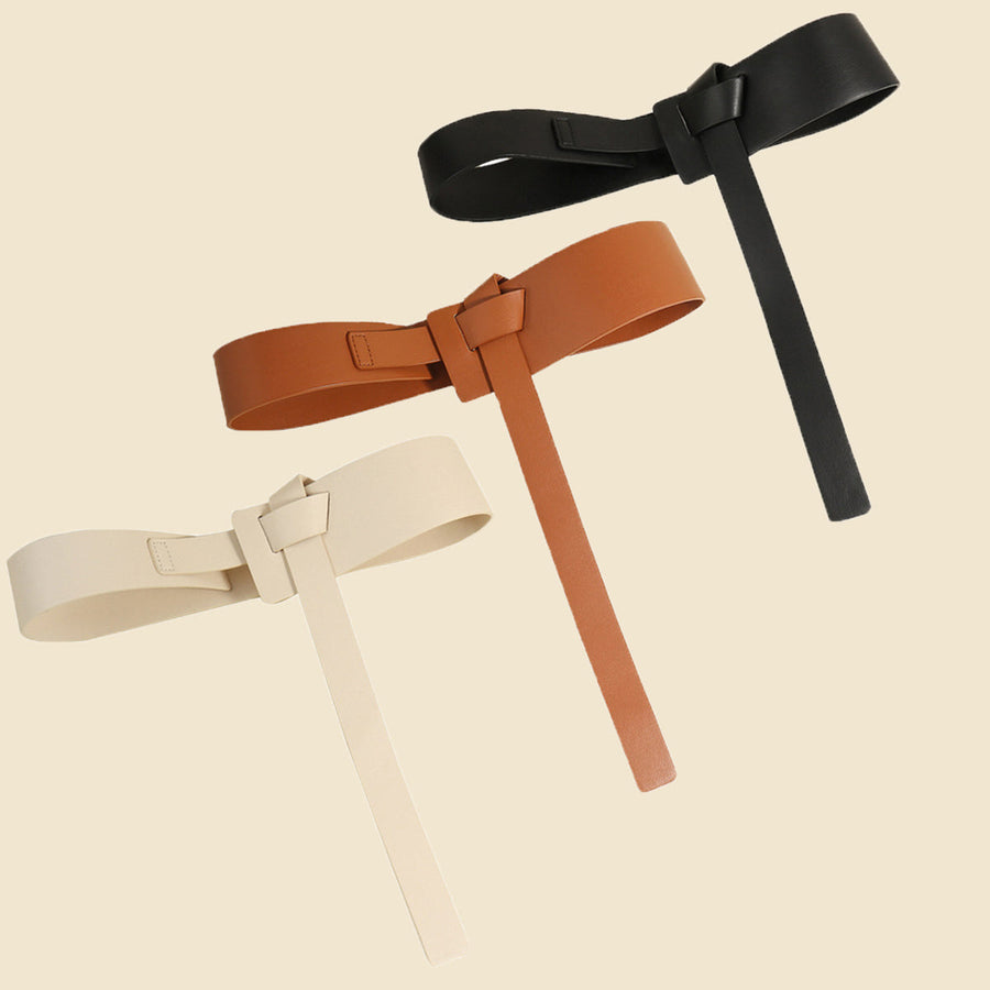 Tied waistband belt with elongated tail in ivory, caramel, and black.