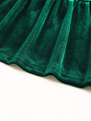Dark green velvet tiered mini dress hem detail with subtle sparkle