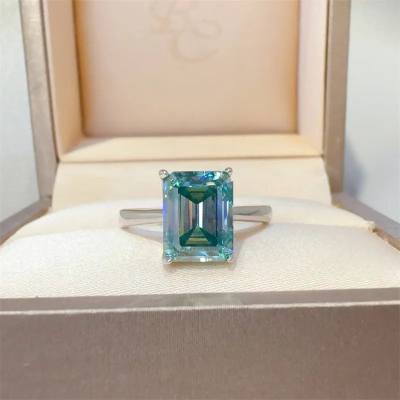 Emerald cut teal moissanite ring in silver with a classic band.