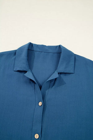 Blue linen blend collared button-up shirt with subtle vertical seams and light wood buttons.
