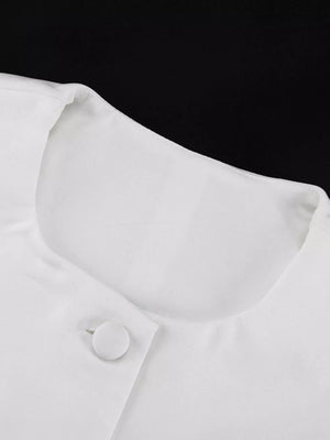 White button-up blouse with a rounded neckline and fabric-covered button.