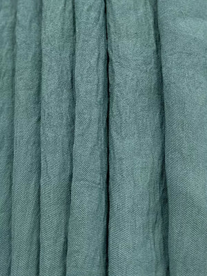 Turquoise linen blend fabric with vertical pleats and visible texture.